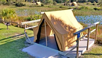 An adventure tent overlooking a scenic pond