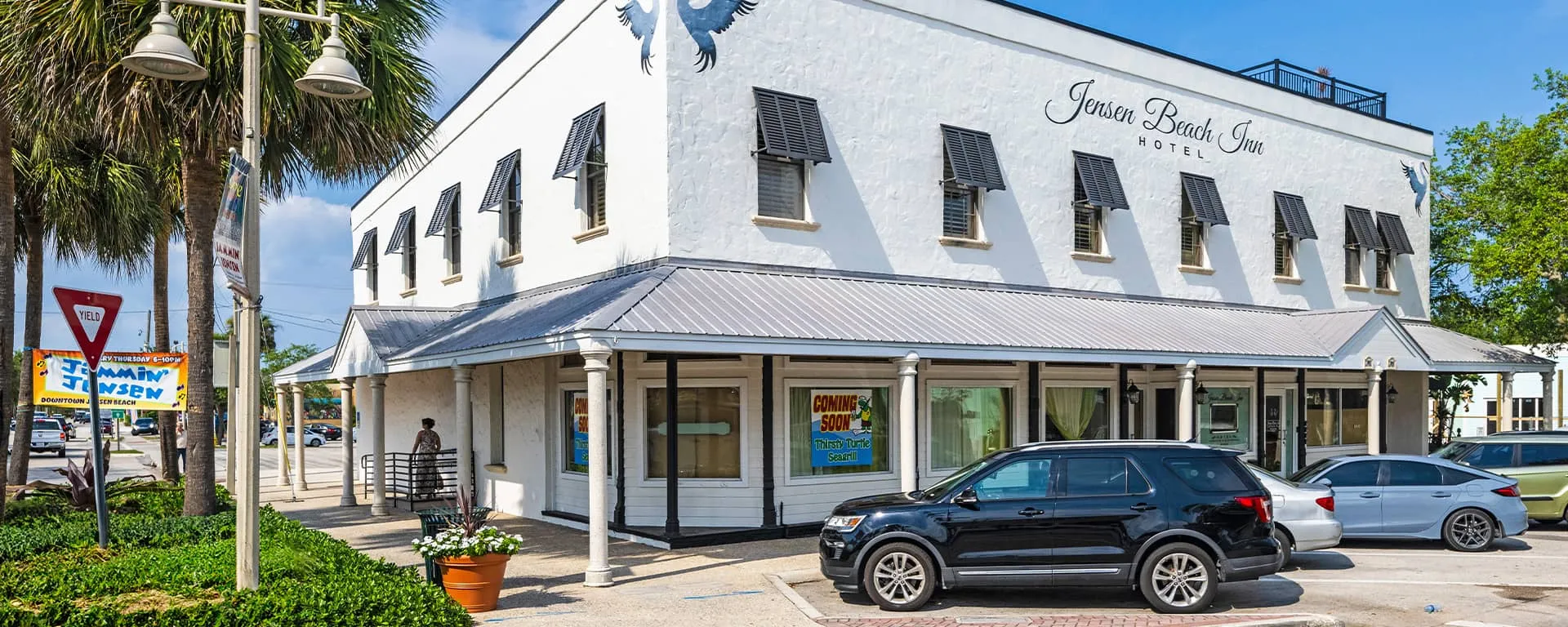 The historic Jensen Beach Inn after being painted white with new black awnings over windows.