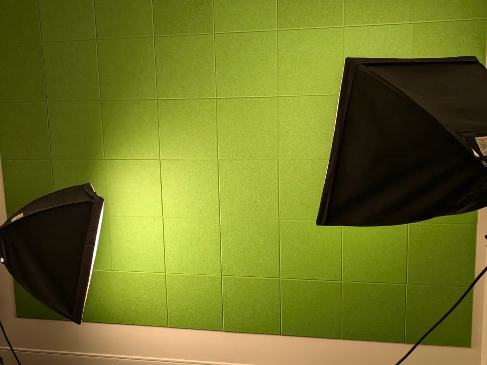 The image shows a green-tiled wall in a studio setting, illuminated by two softbox lights positioned on stands