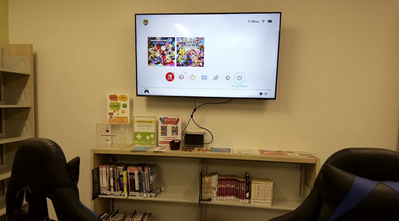 Two chairs in front of a tv with a Nintendo Switch connected to it. 